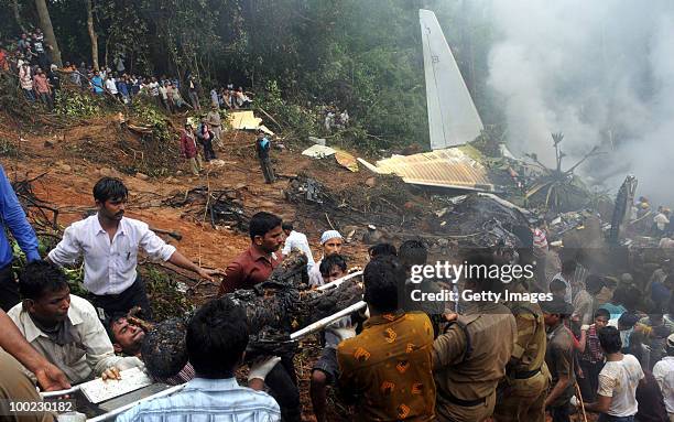 The charred body of a victim is carried from the site of the airline crash, on May 22, 2010 in Mangalore. An Air India Express Boeing 737-800 series...