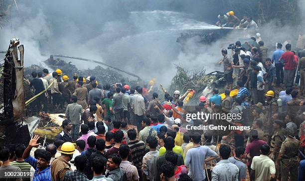 Firemen douse the smoldering remains of the aircraft that crashed, on May 22, 2010 in Mangalore. An Air India Express Boeing 737-800 series aircraft...