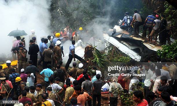 Firemen, paramilitary personnnel and onlookers gather at the site of a plane crash on May 22, 2010 in Mangalore. An Air India Express Boeing 737-800...
