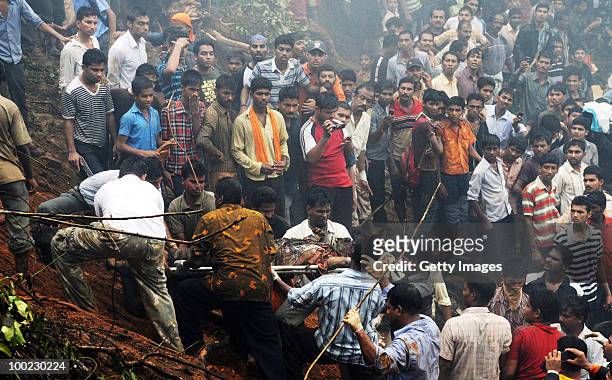 The charred body of a victim is carried from the site of the airline crash, on May 22, 2010 in Mangalore. An Air India Express Boeing 737-800 series...