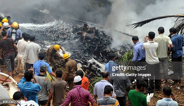 Charred bodies of passengers remain in the wreakage of the aircraft crash as firemen hose it down, on May 22, 2010 in Mangalore. An Air India Express...