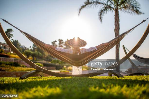 unbeschwerte frau genießen in einem luxus-resort - resort pool stock-fotos und bilder