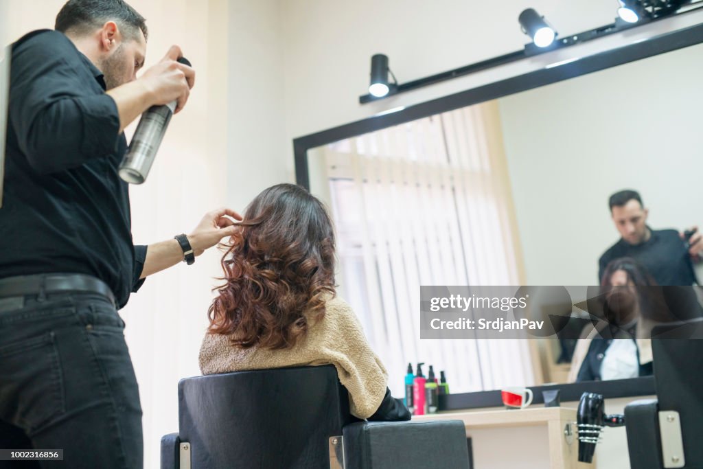 Spraying hair with hair product