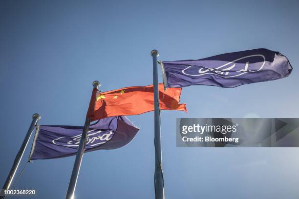 Chinese flag, center, and the Ford Motor Co. Corporate flags are flown at a Ford dealership in Shanghai, China, on Thursday, July 19, 2018. The...