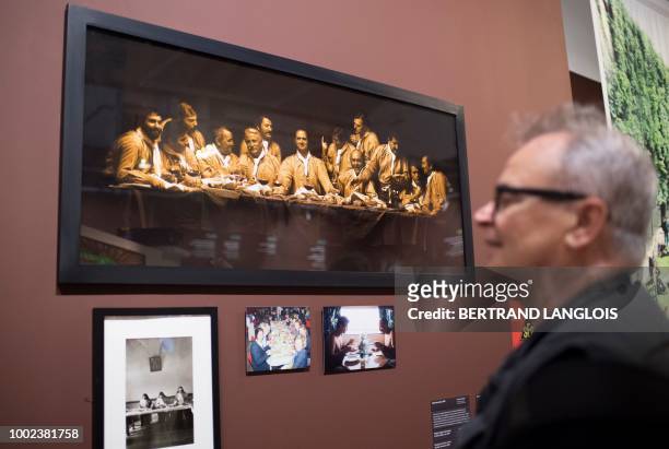 People look at a photograph by Francis Giacobetti during a press preview of the exhibition 'Manger à l'oeil' at the Museum of European and...