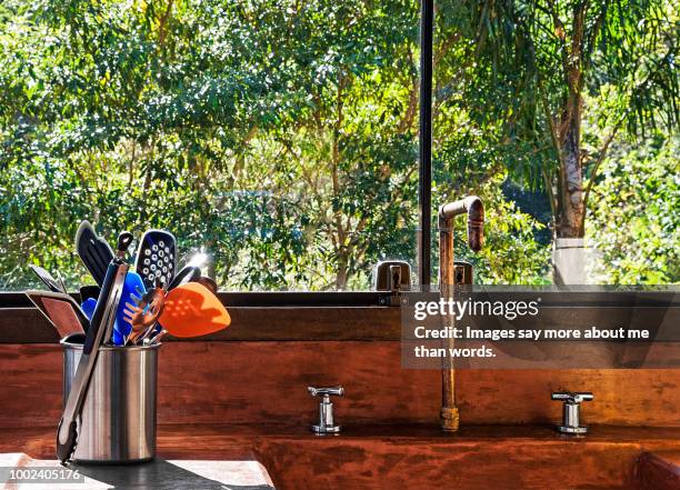 rustic kitchen with copper faucet and terracotta sink . still life - copper still stockfoto's en -beelden