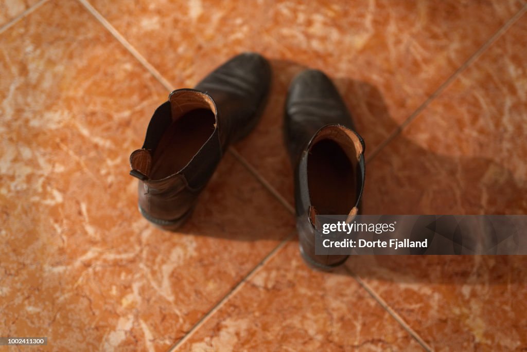 Pair of black boots on a tiled floor
