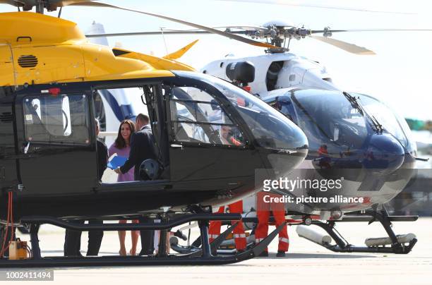 Great Britain's Prince William and Duchess Kate look at an Airbus helicopter with their children George and Charlotte in Hamburg, Germany, 21 July...