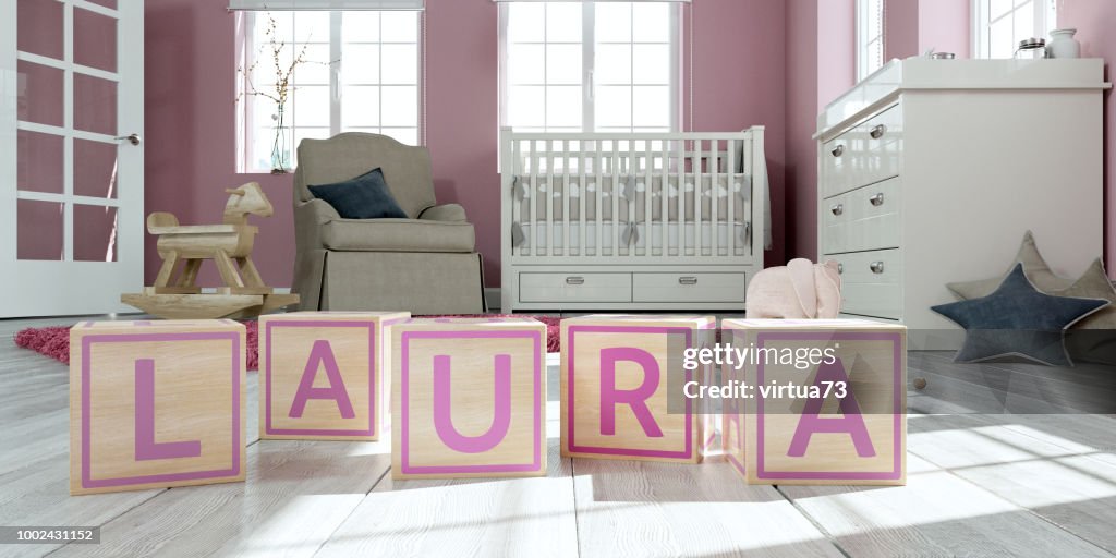 The name laura written with wooden toy cubes in children's room