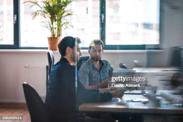 collega's bespreken tijdens de bijeenkomst in office - webdesigner stockfoto's en -beelden