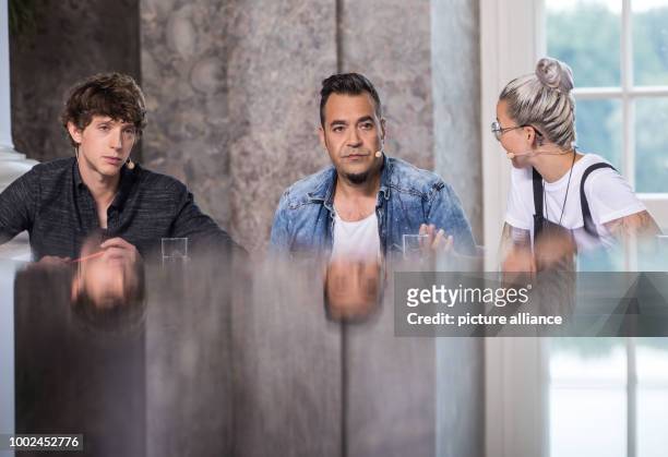 Three of the members of the jury, singers Ole Specht , Laith Al Deen and Stefanie Heinzmann sit at a table during a pause in filming of the casting...