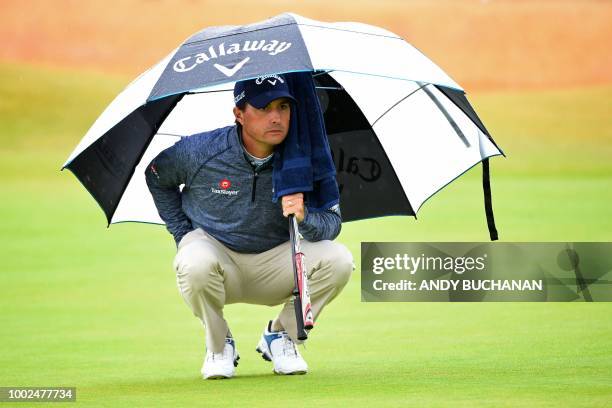 Golfer Kevin Kisner shelters from the rain on the 5th green during his second round on day 2 of The 147th Open golf Championship at Carnoustie,...