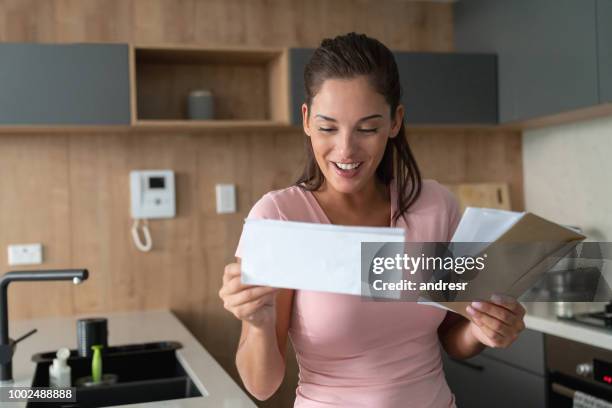 excited woman at home checking her mail - good news letter stock pictures, royalty-free photos & images