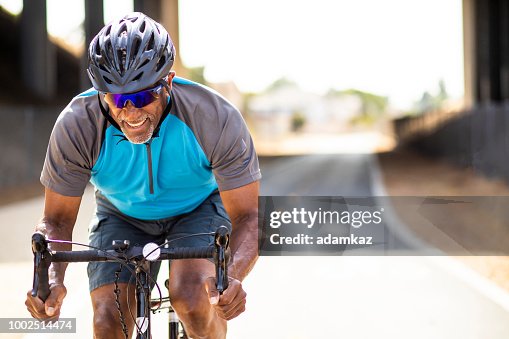 Senior Black Man Racing on a Road Bike Senior Black Man Racing on a Road Bike