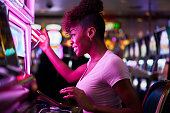 happy woman gambling at casino playing slot machine
