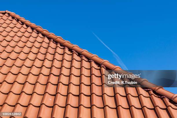 red roof tiles on blue sky - dachziegel stock-fotos und bilder