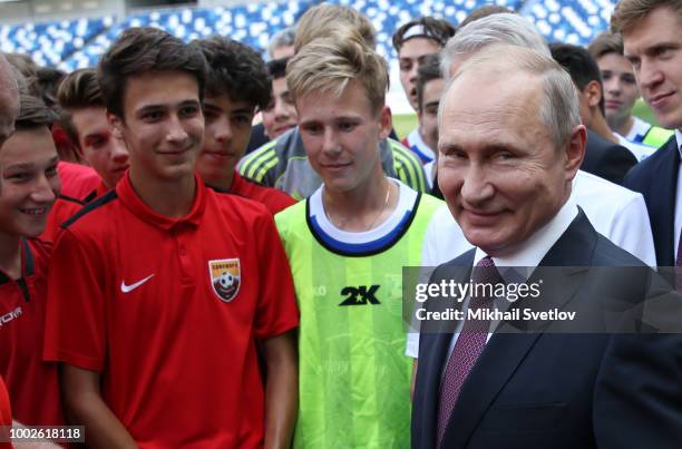 Russian President Vladimir Putin talks to local footballers during their meeting in on the field of Kaliningrad Stadium in Kaliningrad, Russia, July...