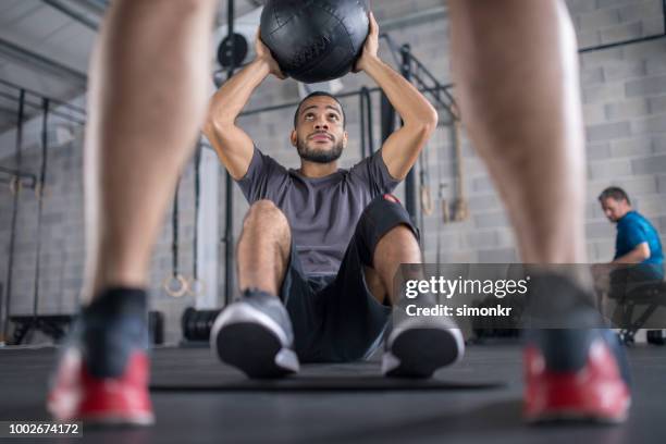 young man practicing with medicine ball - medicine ball stock pictures, royalty-free photos & images