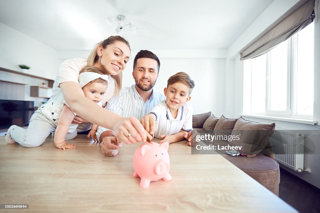 A smiling family saves money with a piggy bank