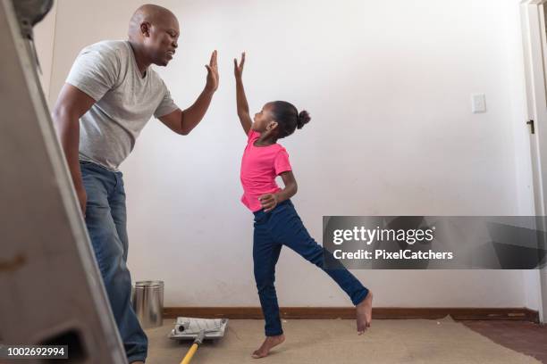 hoge vijf vader en dochter schilderen slaapkamer samen - black man high 5 stockfoto's en -beelden