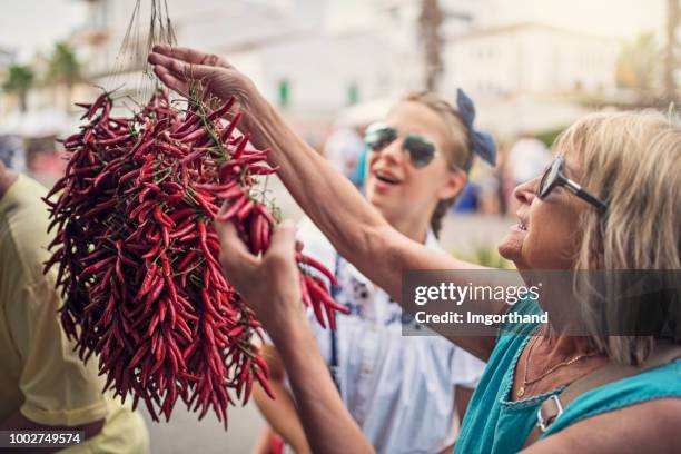 familia compra secado pimientas del chile en el mercado - chili woman fotografías e imágenes de stock