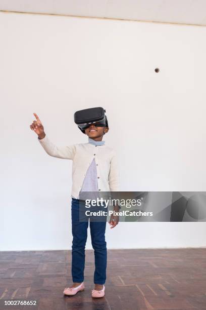full body little girl with vr glasses in new home imagining how it will look - vr kids stock pictures, royalty-free photos & images