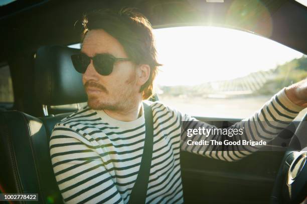 young man driving car on sunny day - man sunglasses stock pictures, royalty-free photos & images