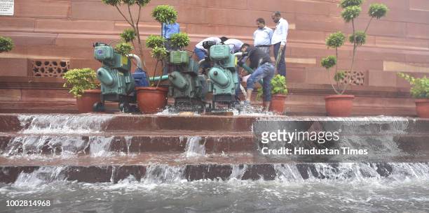 Rain water logged at the premises of Parliament building pumped out using heavy pumps after monsoon rain spell during Monsoon Session of Parliament...