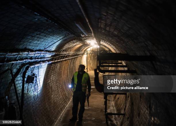 Holger Happel, employee of Berliner Unterwelten e.V. , carrying a pocket lamp walks through the former test tunnel of AEG in Berlin, Germany, 16 May...