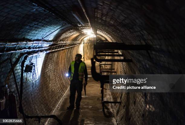 Holger Happel, employee of Berliner Unterwelten e.V. , carrying a pocket lamp walks through the former test tunnel of AEG in Berlin, Germany, 16 May...