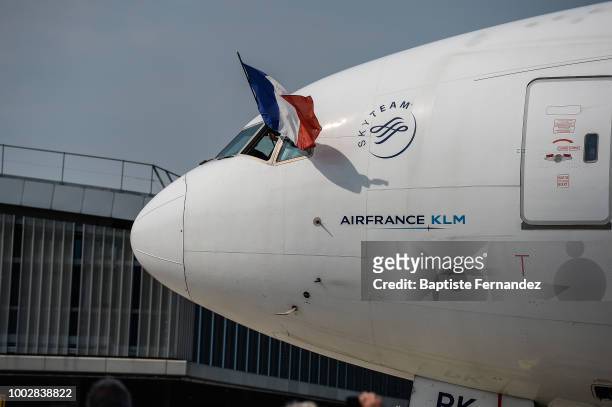 Pilot show the french flag during the arrival at Airport Roissy Charles de Gaulle on July 16, 2018 in Paris, France.