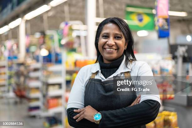 portret van lachende verkoper van een supermarkt - megawinkel stockfoto's en -beelden