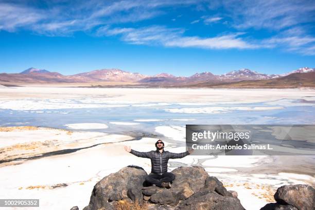 man young adult happy at the red stones salar, near san pedro de atacama. - san pedro de atacama stock-fotos und bilder
