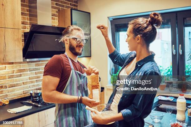playful couple having fun in the kitchen - messy boyfriend stock pictures, royalty-free photos & images