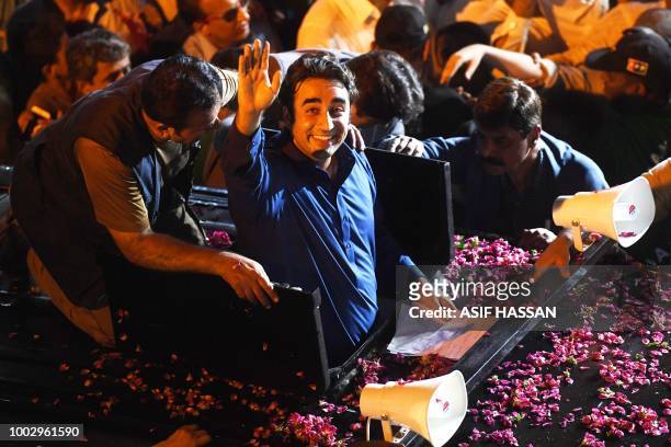Pakistan Peoples Party Chairman Bilawal Bhutto waves to supporters during an election campaign rally in Karachi early on July 21, 2018. - Pakistan...