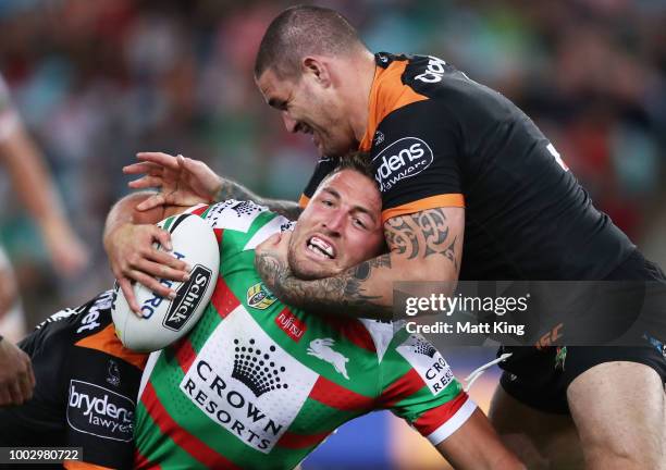 Sam Burgess of the Rabbitohs is tackled during the round 19 NRL match between the Wests Tigers and the South Sydney Rabbitohs at ANZ Stadium on July...