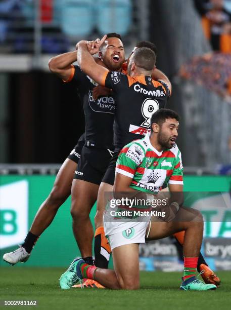 Esan Marsters of the Tigers celebrates with team mates after scoring the first try during the round 19 NRL match between the Wests Tigers and the...