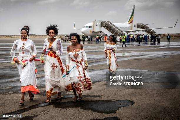 Eritrean women run on the tarmac to welcome passengers of the flight from Ethiopian capital Addis Ababa upon the arrival at Asmara International...
