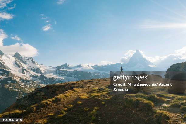 male trail runner ascends above glaciated landscape - trailrunning stock pictures, royalty-free photos & images