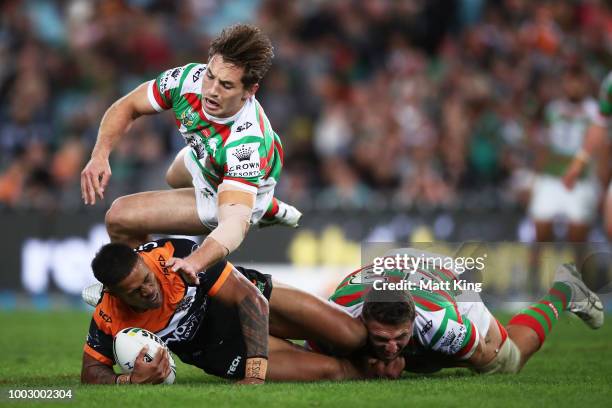 Michael Chee Kam of the Tigers is tackled over the top by Cameron Murray of the Rabbitohs during the round 19 NRL match between the Wests Tigers and...