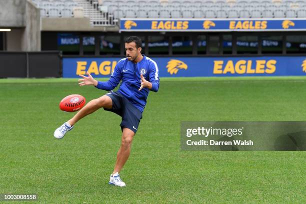 Pedro of Chelsea kicks an AFL ball as he meets AFL Legends Beau Waters and Troy Cook at the Optus Stadium on July 21, 2018 in Perth, Australia.