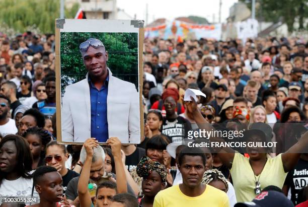 Person holds a portrait of late Adama Traore during a march calling for answers two years after the 24-year-old man died in police custody, on July...