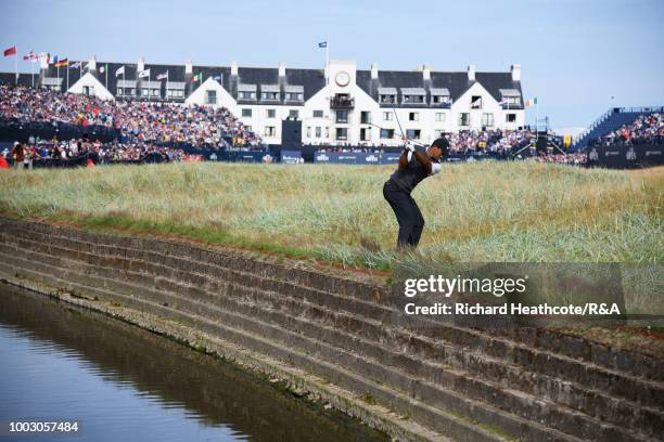 Tiger Woods of the United States plays his second shot from close to the Barry Burn at the 18th hole during round three of the Open Championship at...