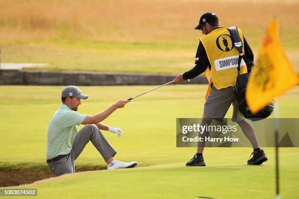 Webb Simpson of the United States is helped out of a bunker by his caddie Paul Tesori on the 18th hole during the third round of the 147th Open...