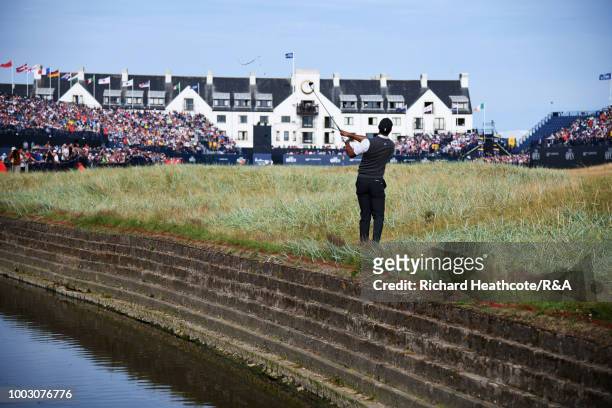 Tiger Woods of the United States plays his second shot from close to the Barry Burn at the 18th hole during round three of the Open Championship at...