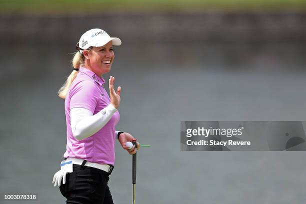 Brittany Licicome waves to the crowd following an eagle on the 17th hole during a continuation of the second round of the Barbasol Championship at...