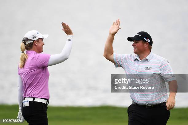 Brittany Lincicome is congratulated by Conrad Shindler after holing out for eagle in the 17th fairway during a continuation of the second round of...
