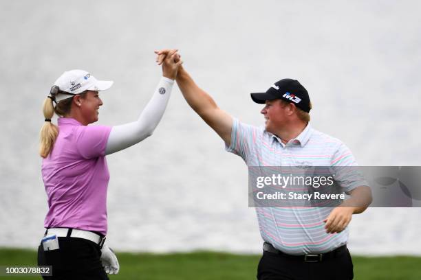 Brittany Lincicome is congratulated by Conrad Shindler after holing out for eagle in the 17th fairway during a continuation of the second round of...