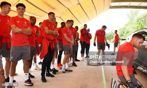 Liverpool players watch as James Milner of Liverpool changing tyres during a tour of Roush Fenway Racing on July 21, 2018 in Charlotte, North...