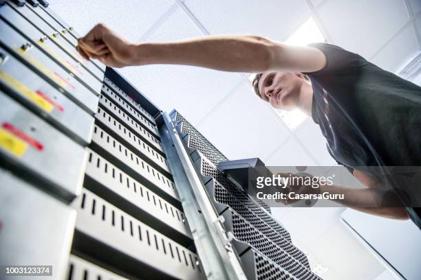 junge it-techniker arbeiten in supercomputer strom backup-zimmer - sicherungskopie stock-fotos und bilder